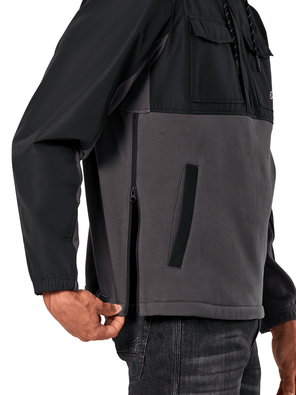Alpinestars Juncture Hybrid jas in Black Gunmetal, detailweergave van de zijkant met focus op de zijrits en onderste paspelzak, ontwerp van gemengde materialen met grijs canvas fleece en zwarte ripstop overlays, casual op motorsport geïnspireerde streetwear
