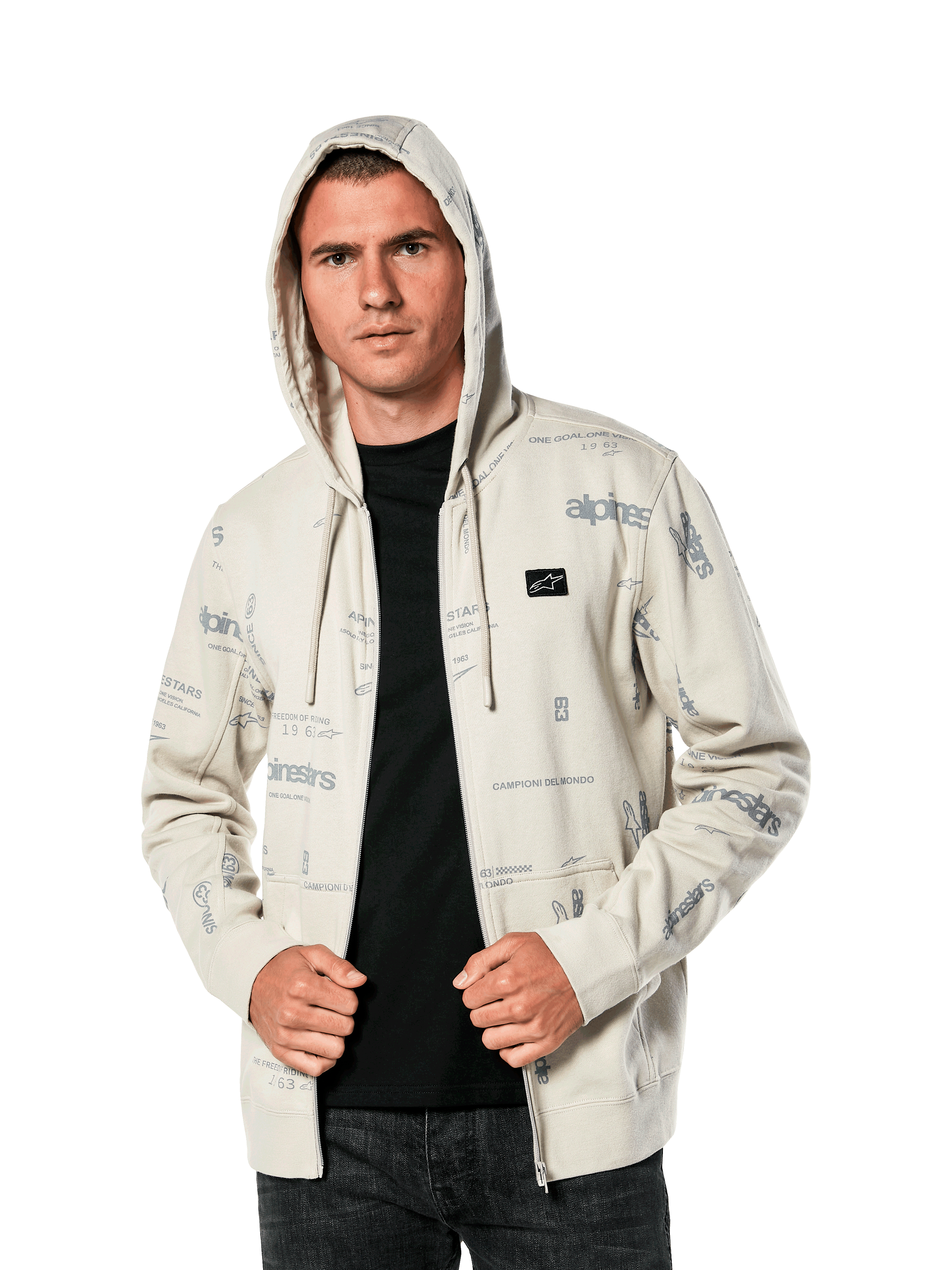 Alpinestars Plenitude Hoodie, casual sportswear, Off White zip-front fleece with all-over grey logo graphics, worn by a man with the hood up over a black shirt, featuring a small chest logo patch and kangaroo pocket
