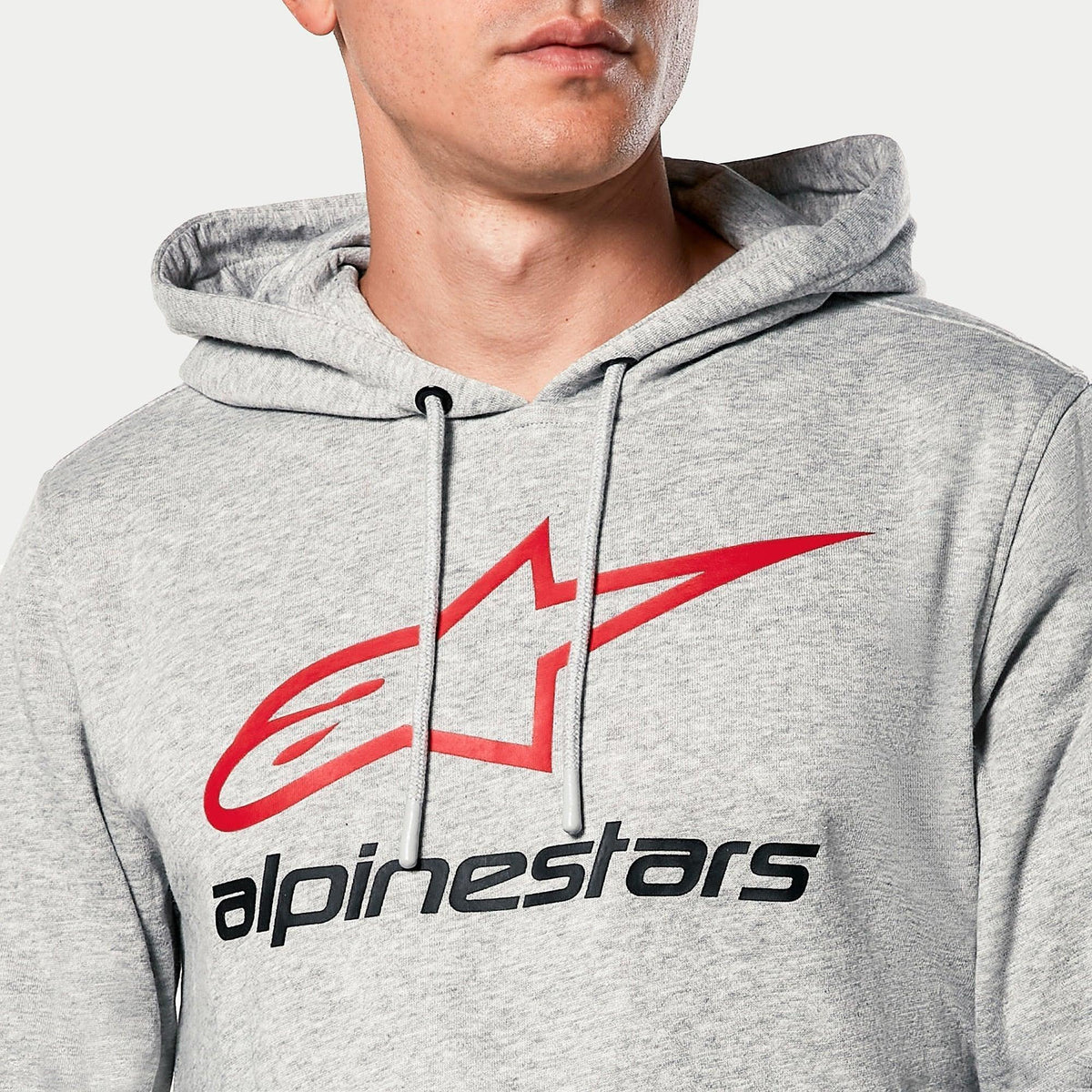 Alpinestars Always V3 Kapuzenpullover, Grau Meliert, Nahaufnahme der Brust mit rotem Stern-Logo und schwarzem Alpinestars-Schriftzug, jersey-gefütterte Kapuze mit grauen Kordelzügen, lässige Motorsport-Streetwear