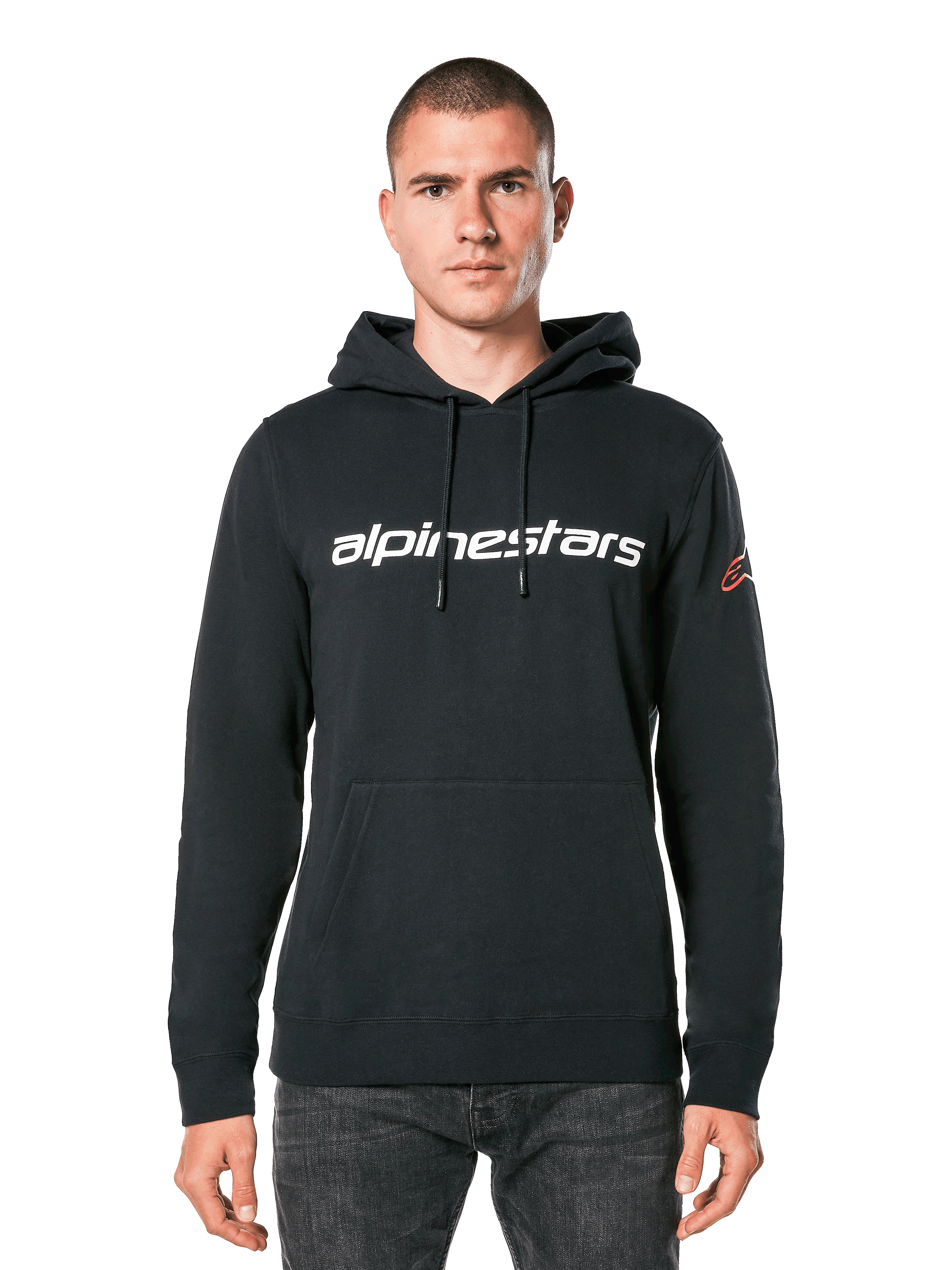 Sweat à capuche Alpinestars Linear Wordmark V3, sweat à capuche noir, logo Alpinestars blanc sur la poitrine, logo Ageless rouge sur la manche, poche kangourou, capuche à cordon de serrage, porté par un mannequin homme, streetwear décontracté inspiré des sports mécaniques
