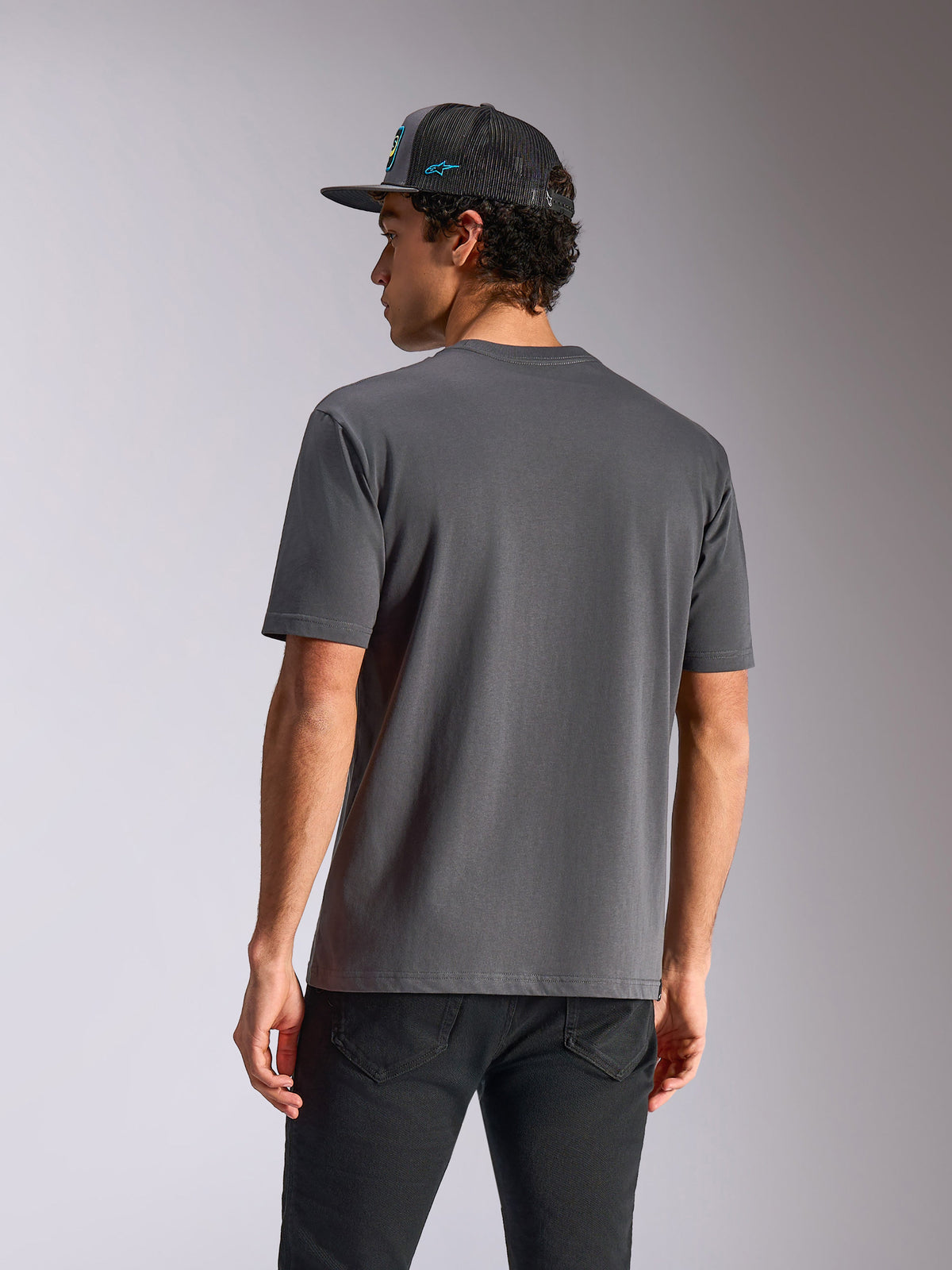 Alpinestars Blaze 2.0 CSF Tee, T-shirt met korte mouwen, antracietgrijs, achteraanzicht, gedragen met zwarte jeans en een mesh pet, casual op motorsport geïnspireerde streetwear
