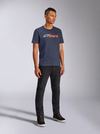 Alpinestars Blaze 2.0 CSF Tee, T-shirt met korte mouwen, marineblauw met wit en oranje Blaze-logo, gedragen door model met zwarte broek en sneakers, casual op motorsport geïnspireerde streetwear