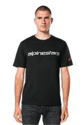 Alpinestars Linear Wordmark 2.0 CSF Tee, t-shirt met korte mouwen, zwart, grijs lineair woordmerk over de borst en rood Ageless-logo op de mouw, gedragen door een model met donkere jeans, casual op motorsport geïnspireerde streetwear