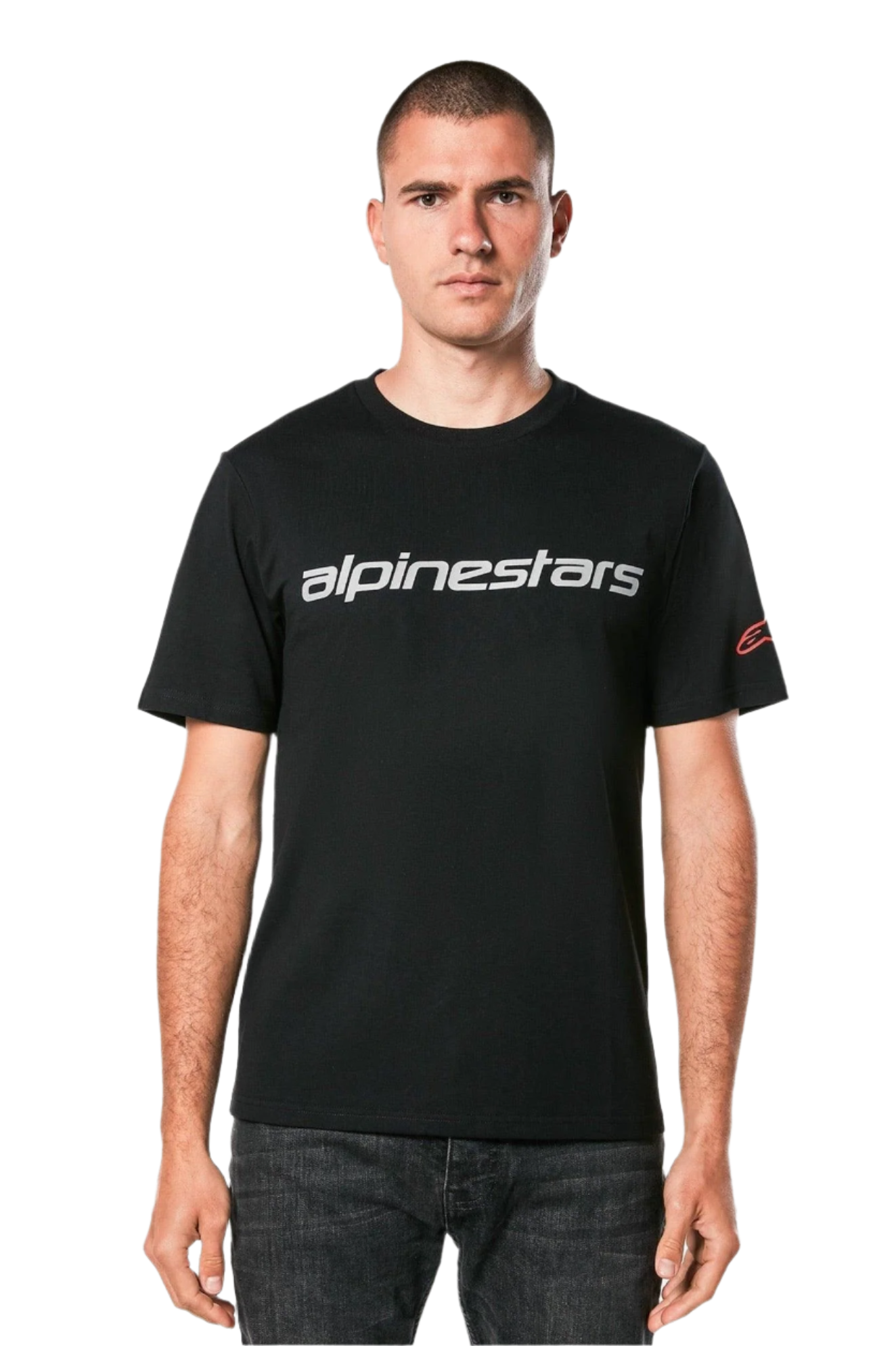 Alpinestars Linear Wordmark 2.0 CSF Tee, t-shirt met korte mouwen, zwart, grijs lineair woordmerk over de borst en rood Ageless-logo op de mouw, gedragen door een model met donkere jeans, casual op motorsport geïnspireerde streetwear