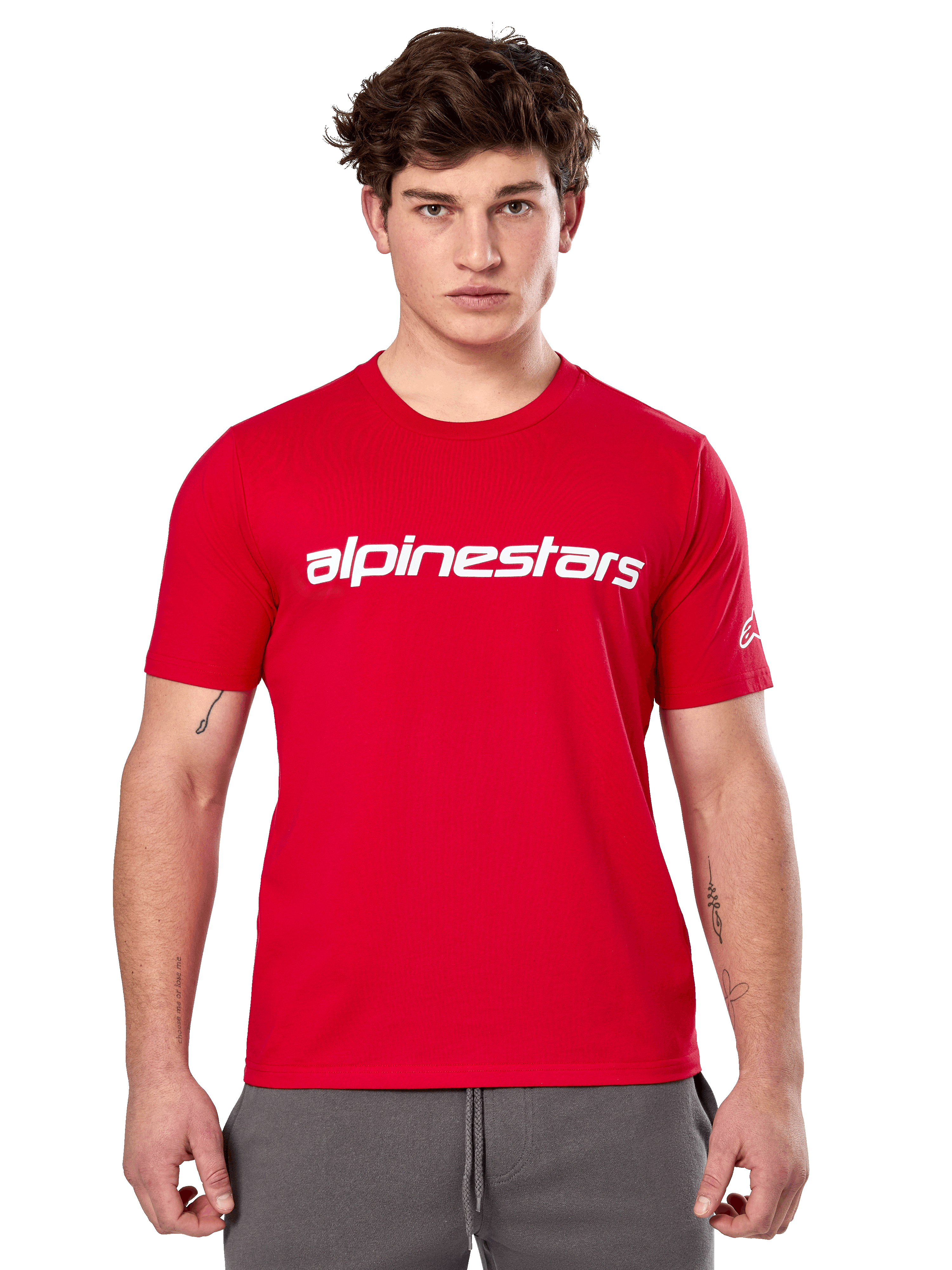 Alpinestars Linear Wordmark 2.0 CSF T-shirt, rood shirt met korte mouwen, wit lineair woordmerk op de borst en Ageless-logo op de mouw, mannelijk model met grijze joggingbroek, casual motorsport-geïnspireerde streetwear