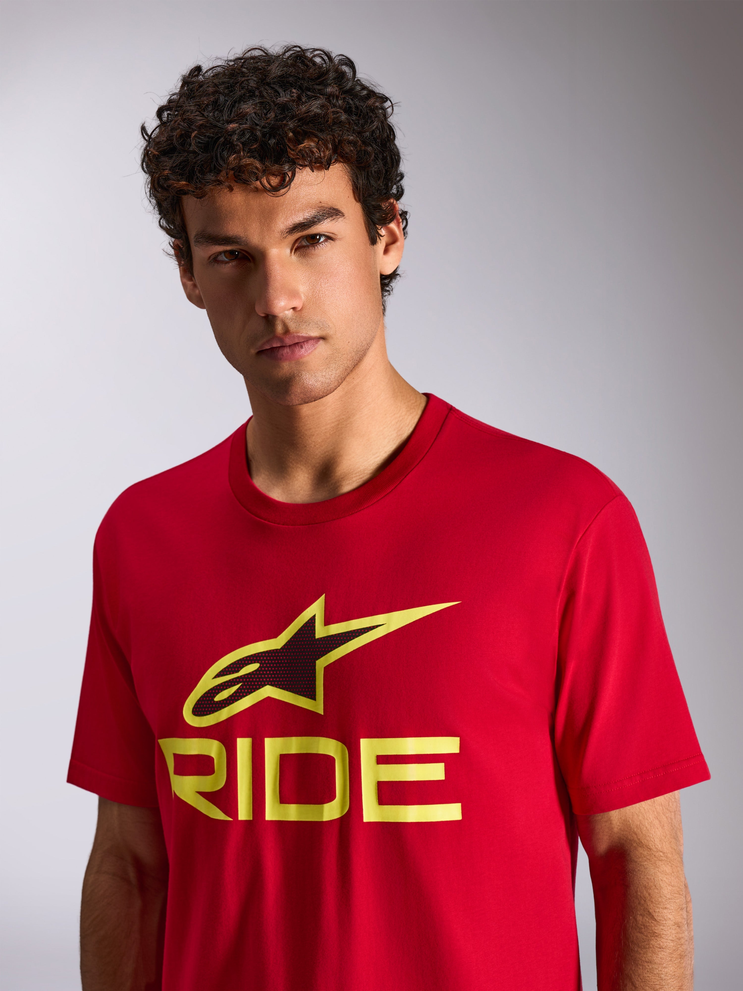 Alpinestars Ride 4.0 CSF Tee, T-shirt met korte mouwen, rood met hi-vis geel en zwart Ride-logo, gedragen door model, casual motorsport streetwear