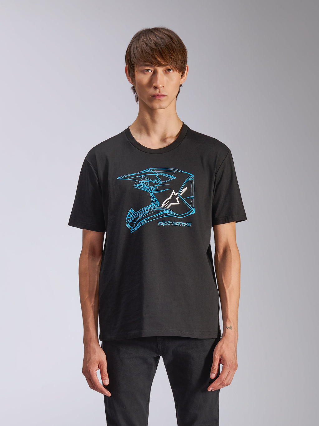 Alpinestars CSF Tee, t-shirt à manches courtes noir, graphisme de casque de motocross bleu avec logo Astars blanc, streetwear décontracté d'inspiration sport automobile porté par un mannequin