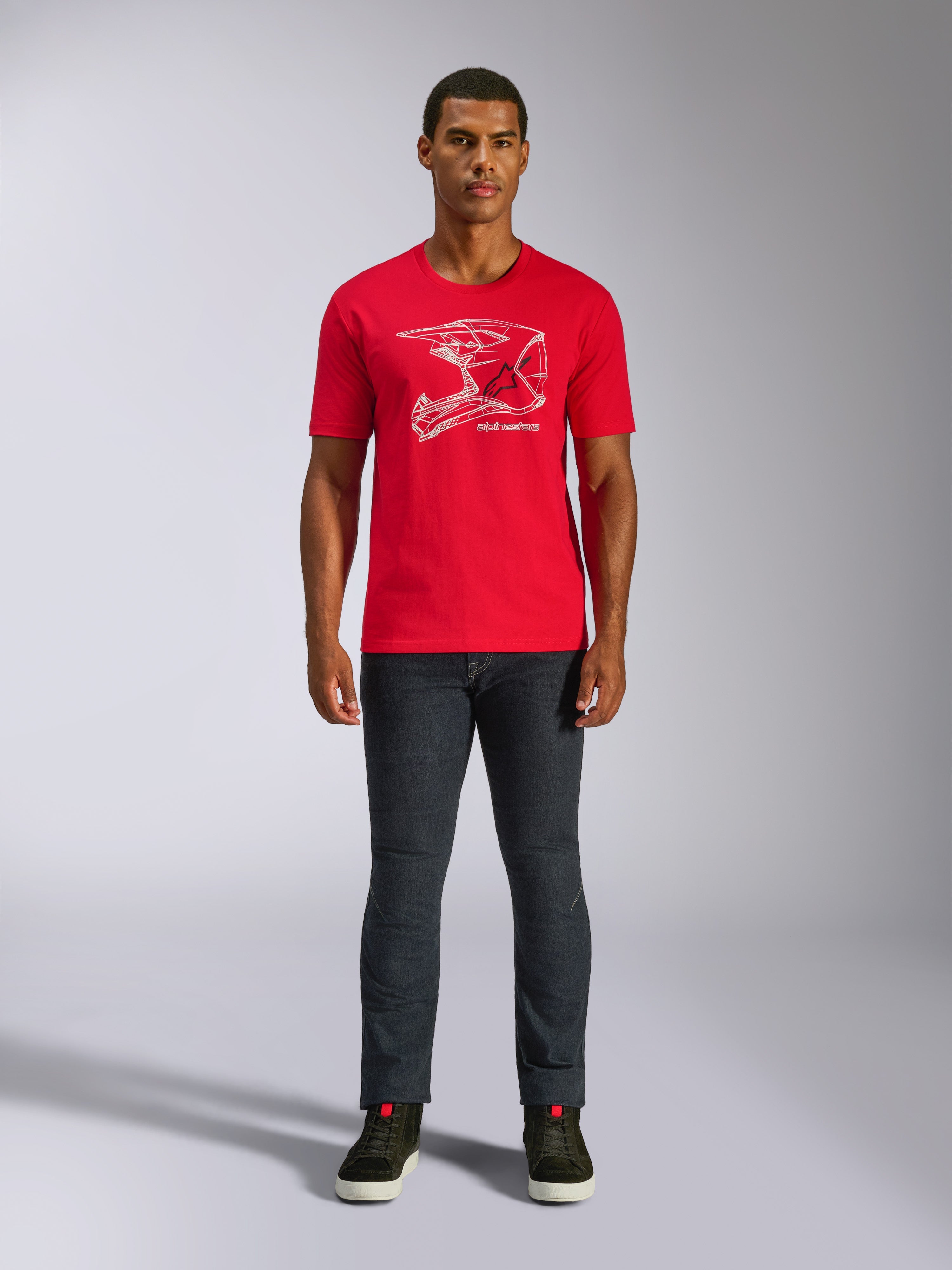 T-shirt Alpinestars MX Helmet CSF, t-shirt à manches courtes, rouge, graphisme de casque MX blanc, vêtement de sport mécanique décontracté, porté avec un jean foncé et des baskets