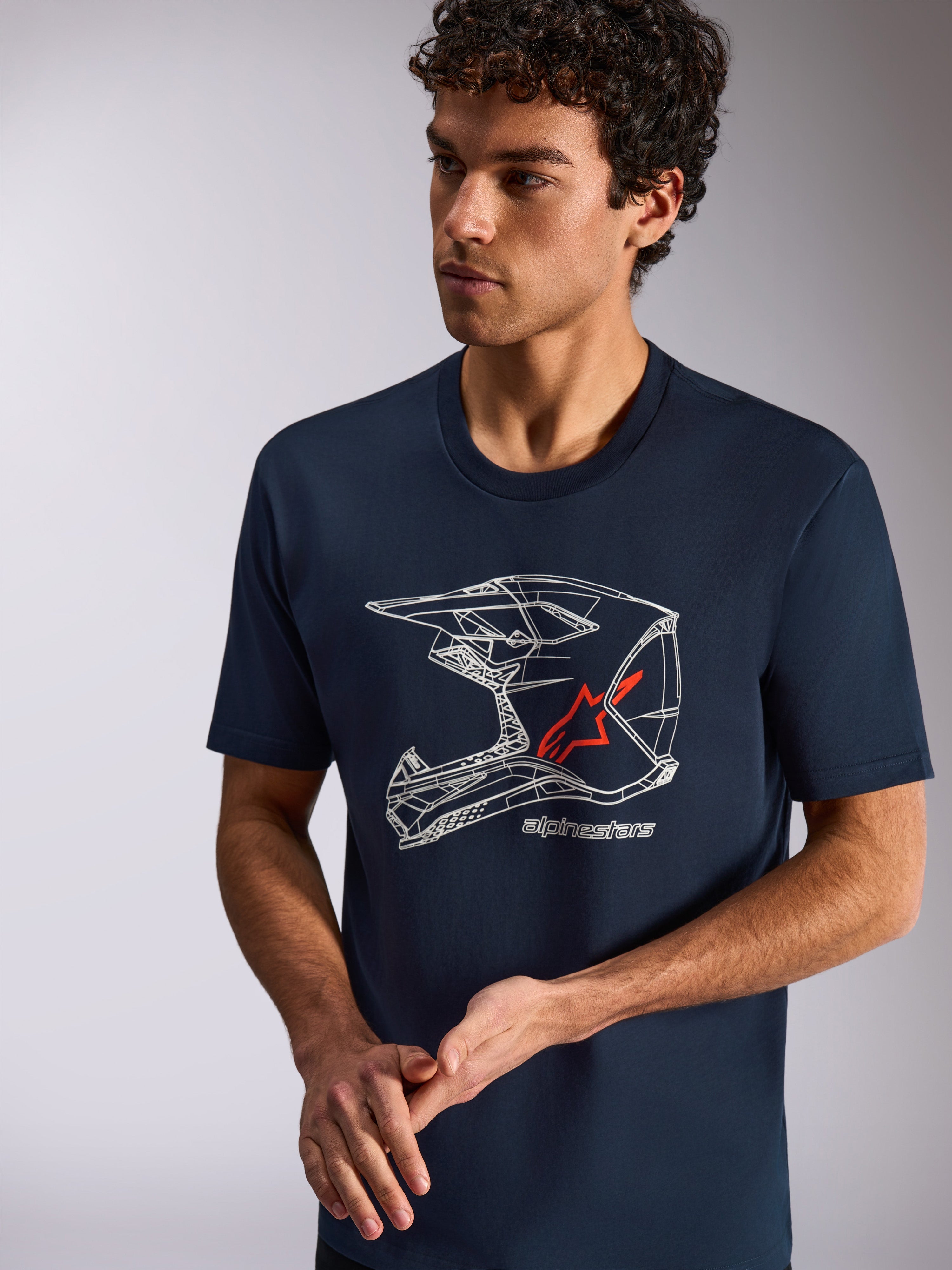 Alpinestars MX Helmet CSF Tee, T-shirt met korte mouwen, marineblauw, witte MX-helm graphic met rood sterlogo, casual sportkleding gedragen door model