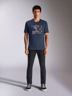 Alpinestars MX Helmet CSF Tee, T-shirt met korte mouwen, marineblauw, met witte motorcrosshelm-graphic en rood sterlogo, gedragen door model met zwarte broek en sneakers, casual motorsport-geïnspireerde streetwear