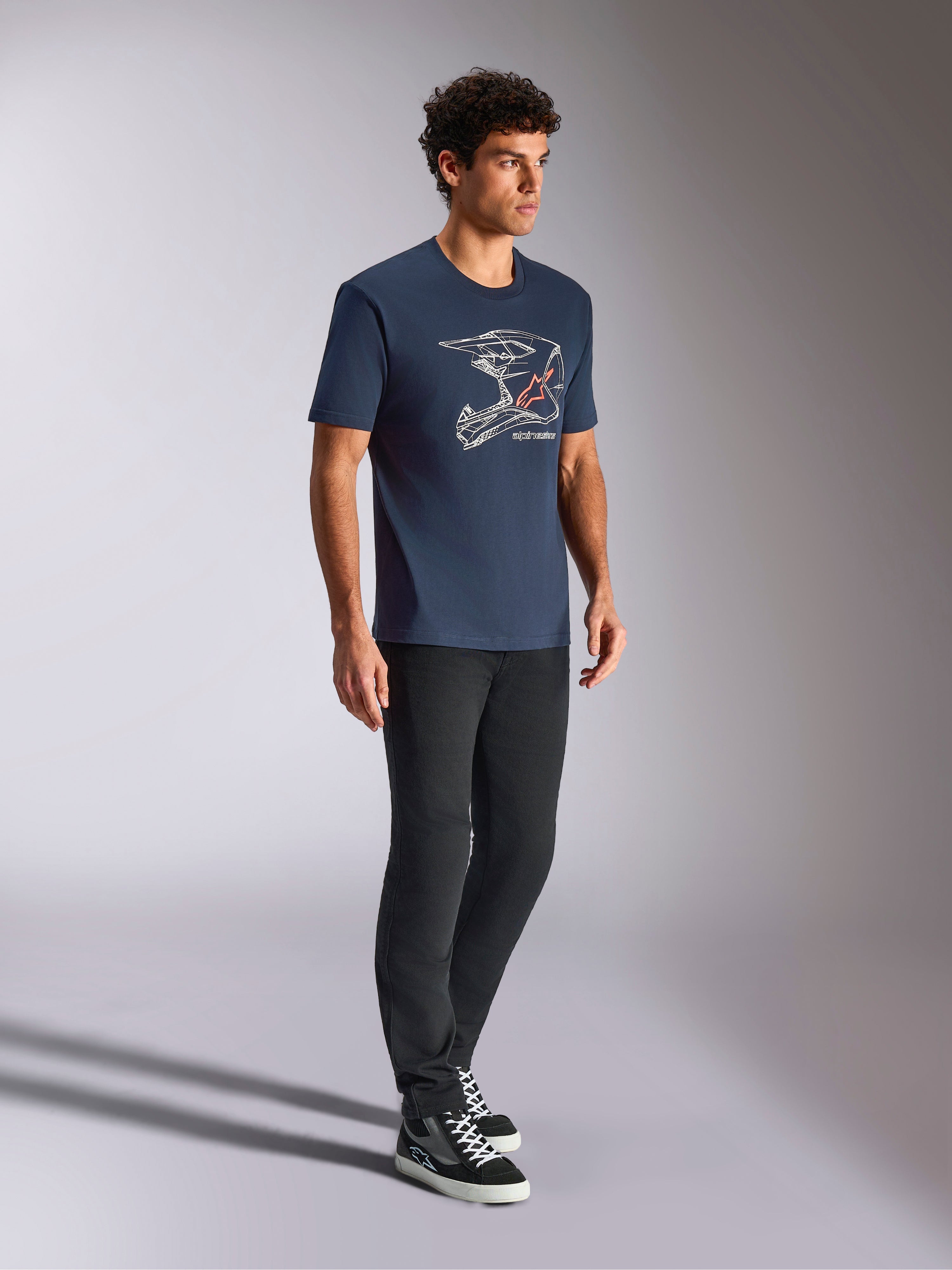 Alpinestars MX Helmet CSF Tee, T-shirt met korte mouwen, marineblauw, met witte lijntekening van een motorcrosshelm en rood sterlogo, casual motorsport-geïnspireerde streetwear gedragen met een zwarte broek en hoge sneakers
