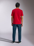 Alpinestars Ageless Shadow CSF Tee, achteraanzicht van rood T-shirt met korte mouwen, gedragen met donkerblauwe denim jeans en zwarte sneakers, casual motorsport streetwear