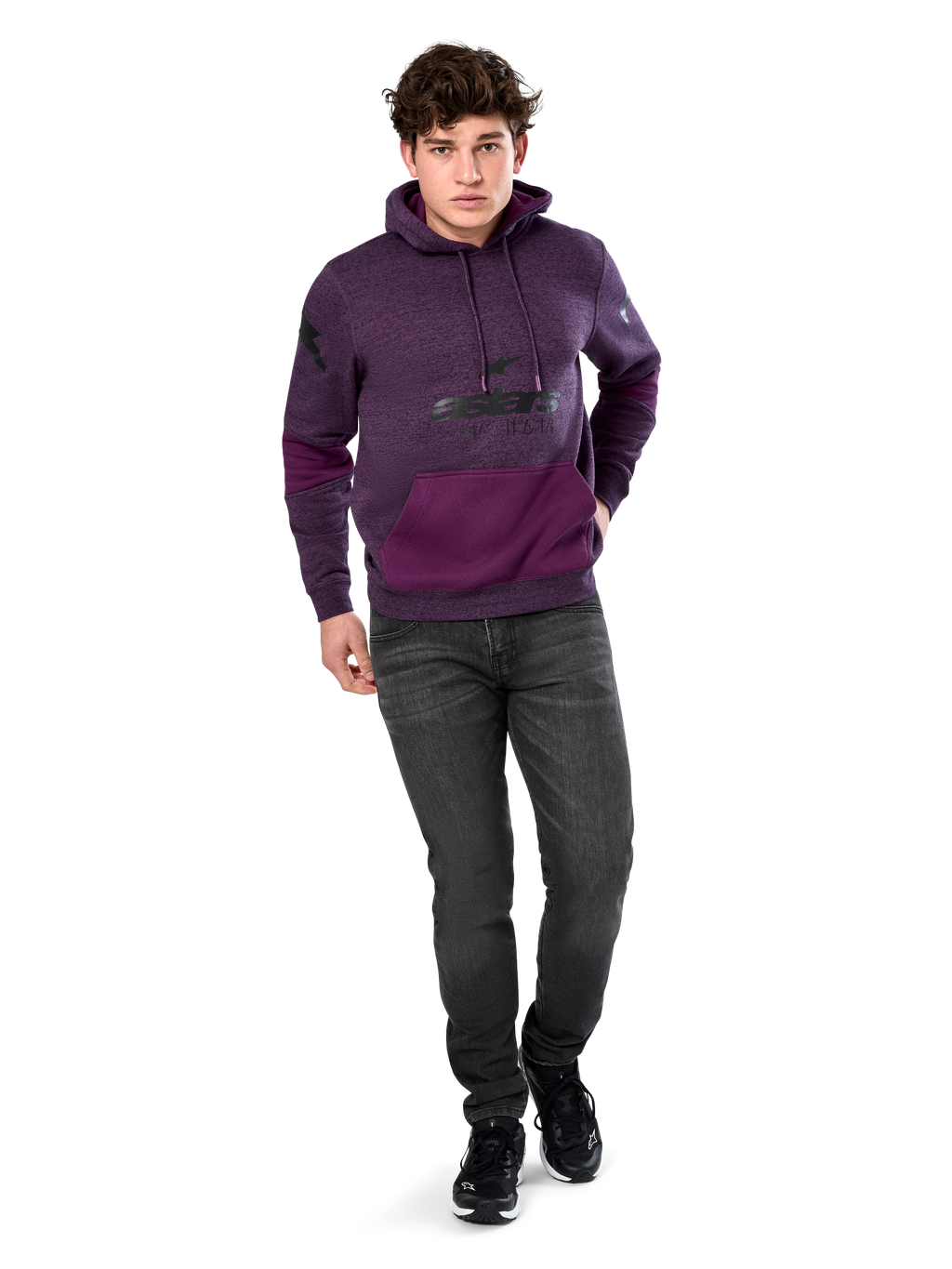 Alpinestars Perpetuate Hoodie, casual streetwear, paars gemêleerd fleece met donkerpaarse kleurvlakken op de kangoeroezak en mouwen, zwart logo op de borst, capuchon met trekkoord, gedragen door model met donkergrijze jeans en zwarte sneakers