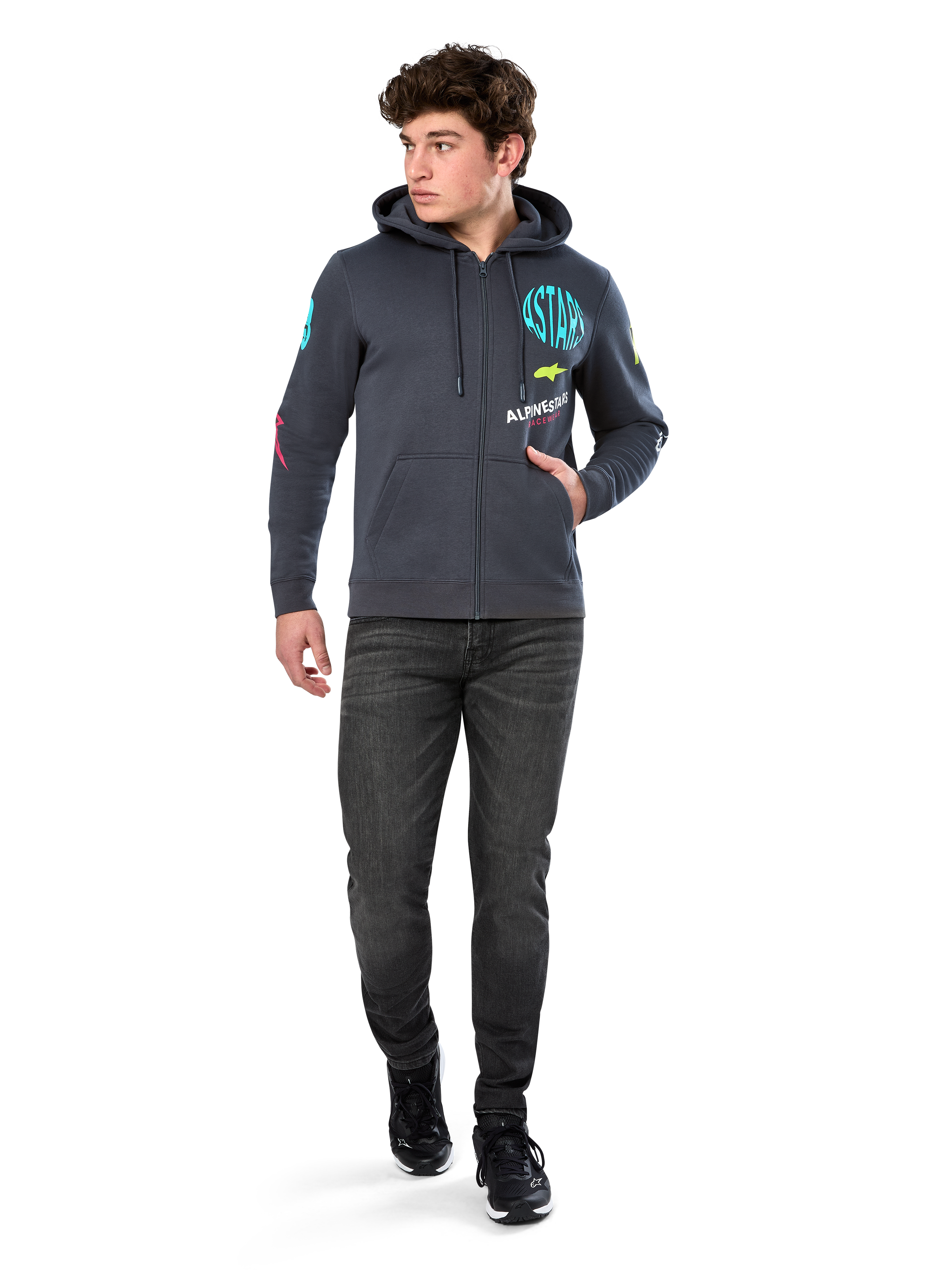 Alpinestars Variegate Hoodie, fleece hoodie met ritssluiting, Gunmetal grijs, gedragen door een model met zwarte jeans en sneakers, voorzien van teal 'ASTARS' branding en kleurrijke logo-art op de mouwen en borst, casual op de motorsport geïnspireerde streetwear