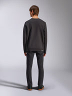 Alpinestars Positive Crew, sweatshirt noir, vue arrière sur un mannequin homme, porté avec un jean noir et des baskets décontractées, doté de poignets et d'un ourlet côtelés, streetwear d'inspiration sport mécanique