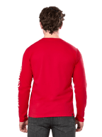 Achteraanzicht van een man die het Alpinestars Committed CSF longsleeve T-shirt in het rood draagt, gecombineerd met een donkergrijze jeans, met een zichtbaar wit Alpinestars-logo op de mouw en een minimalistisch ontwerp op de rug.