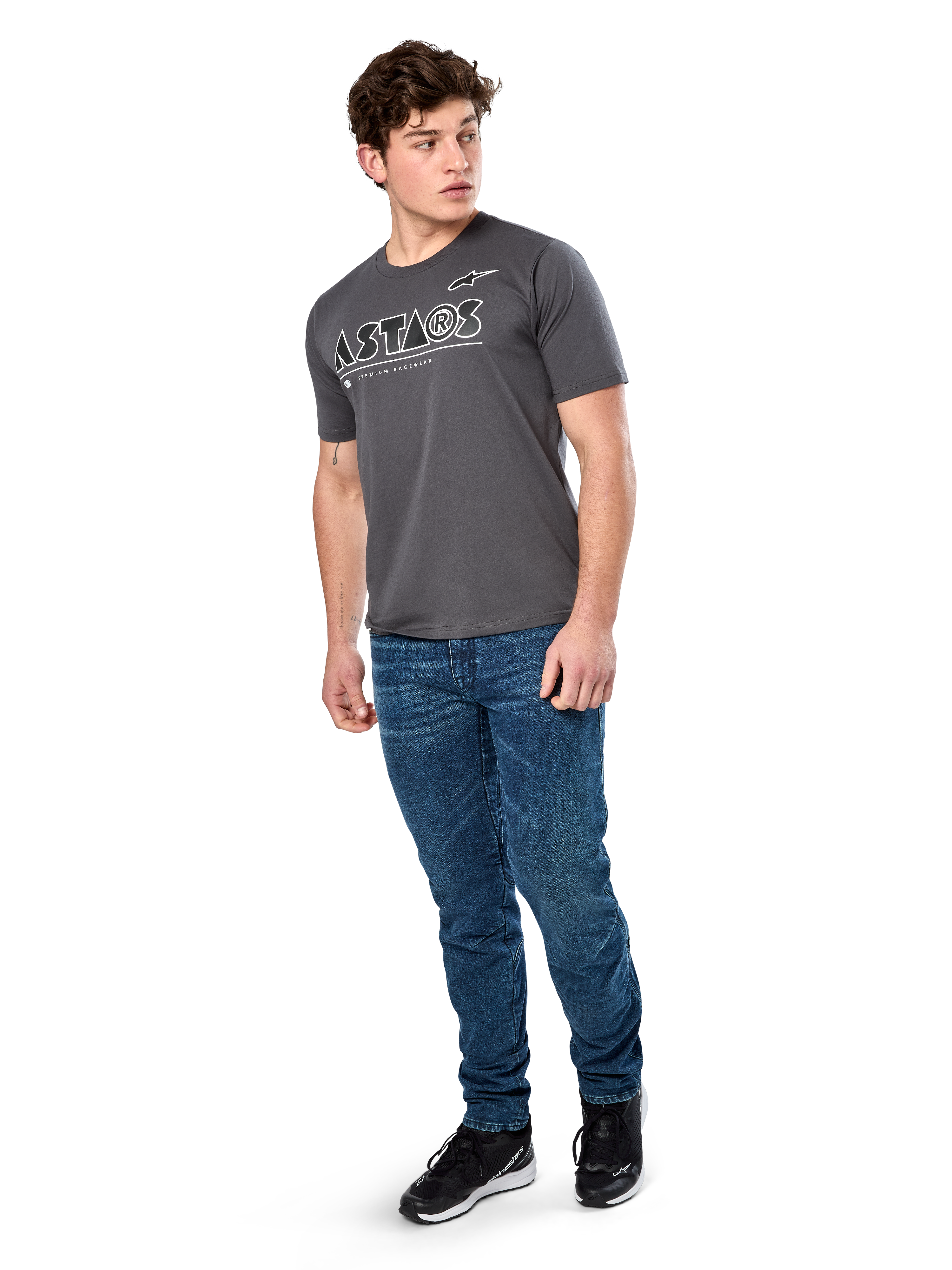 Alpinestars Cereal CSF Tee, T-shirt met korte mouwen, charcoal, wit geometrisch Astars-tekstlogo, casual motorsport-streetwear gedragen met blauwe jeans en zwarte sneakers
