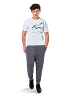 Alpinestars Geografica CSF Tee, T-shirt met korte mouwen, wit, groen Astars-logo met geografische multi-tech graphic, gedragen met grijze joggingbroek en zwarte sneakers, casual motorsport streetwear