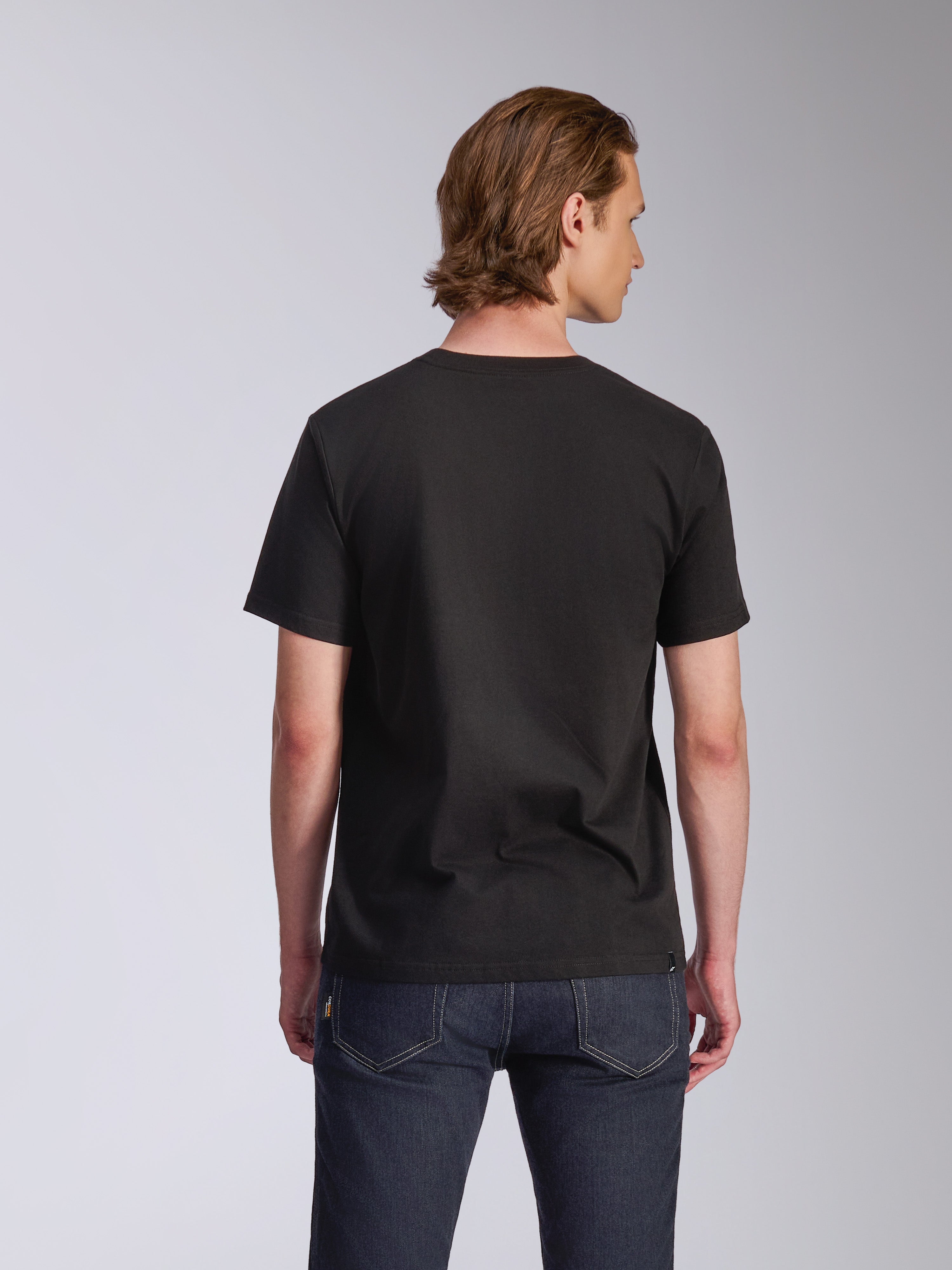 Alpinestars Luxo CSF Tee, T-shirt met korte mouwen, zwart, achteraanzicht, gedragen door een model met donkerblauwe jeans, casual motorsport-geïnspireerde streetwear