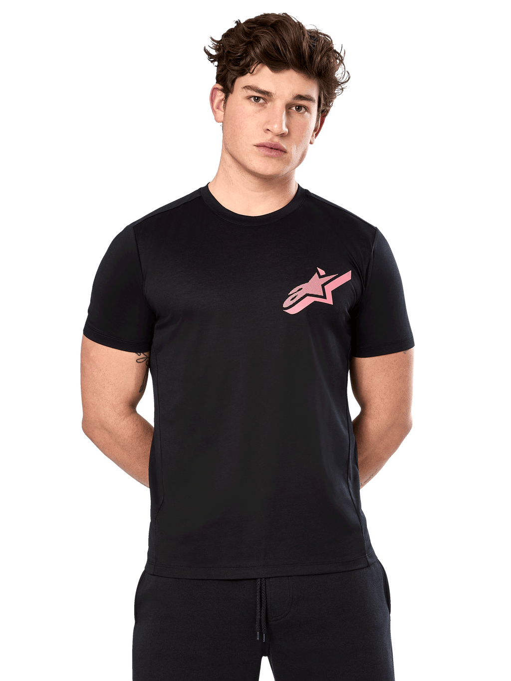 Alpinestars Attrition Performance Tee, T-shirt met korte mouwen, zwart met roze Astars-logo op de borst, gedragen door mannelijk model, casual motorsport performance kleding