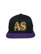 Alpinestars Franchise pet, zwart-paarse pet met platte klep, gestructureerde kroon met paarse klep en knoop bovenop, voorzien van een goud 3D-geborduurd "AS"-logo op de voorkant, casual motorsport-geïnspireerde streetwear