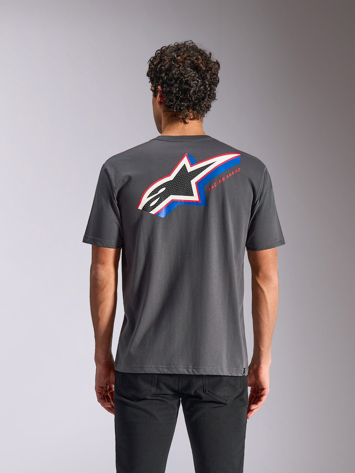 Alpinestars Angler CSF Tee, T-shirt met korte mouwen, antraciet, achteraanzicht met een groot Astars-logo met blauwe en rode accenten en 'RACING AHEAD'-tekst, casual motorsport streetwear