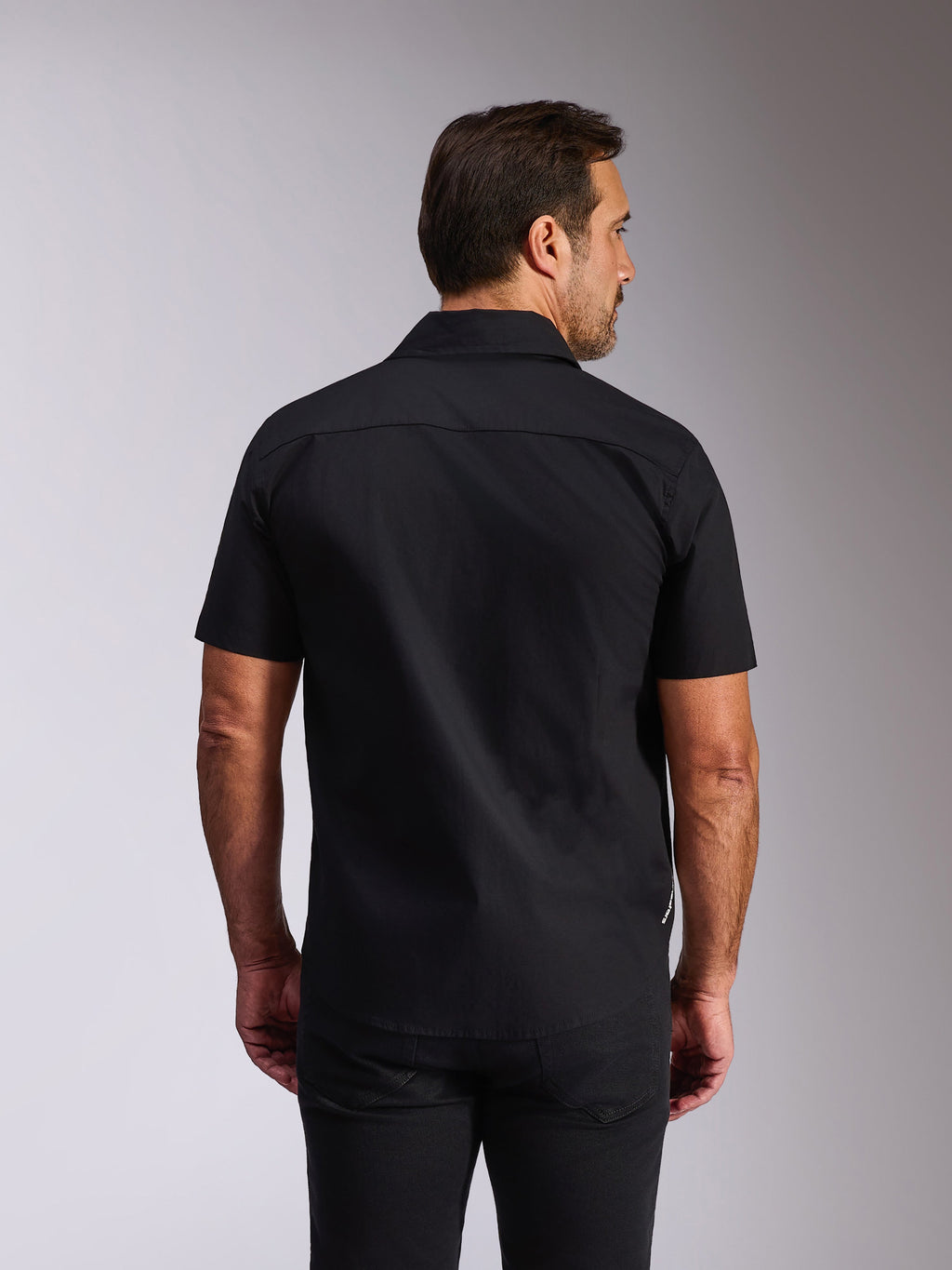Alpinestars Strive Woven Shirt, zwart overhemd met korte mouwen en knoopsluiting, achteraanzicht met rugpand en getailleerde pasvorm, casual streetwear geïnspireerd op de motorsport