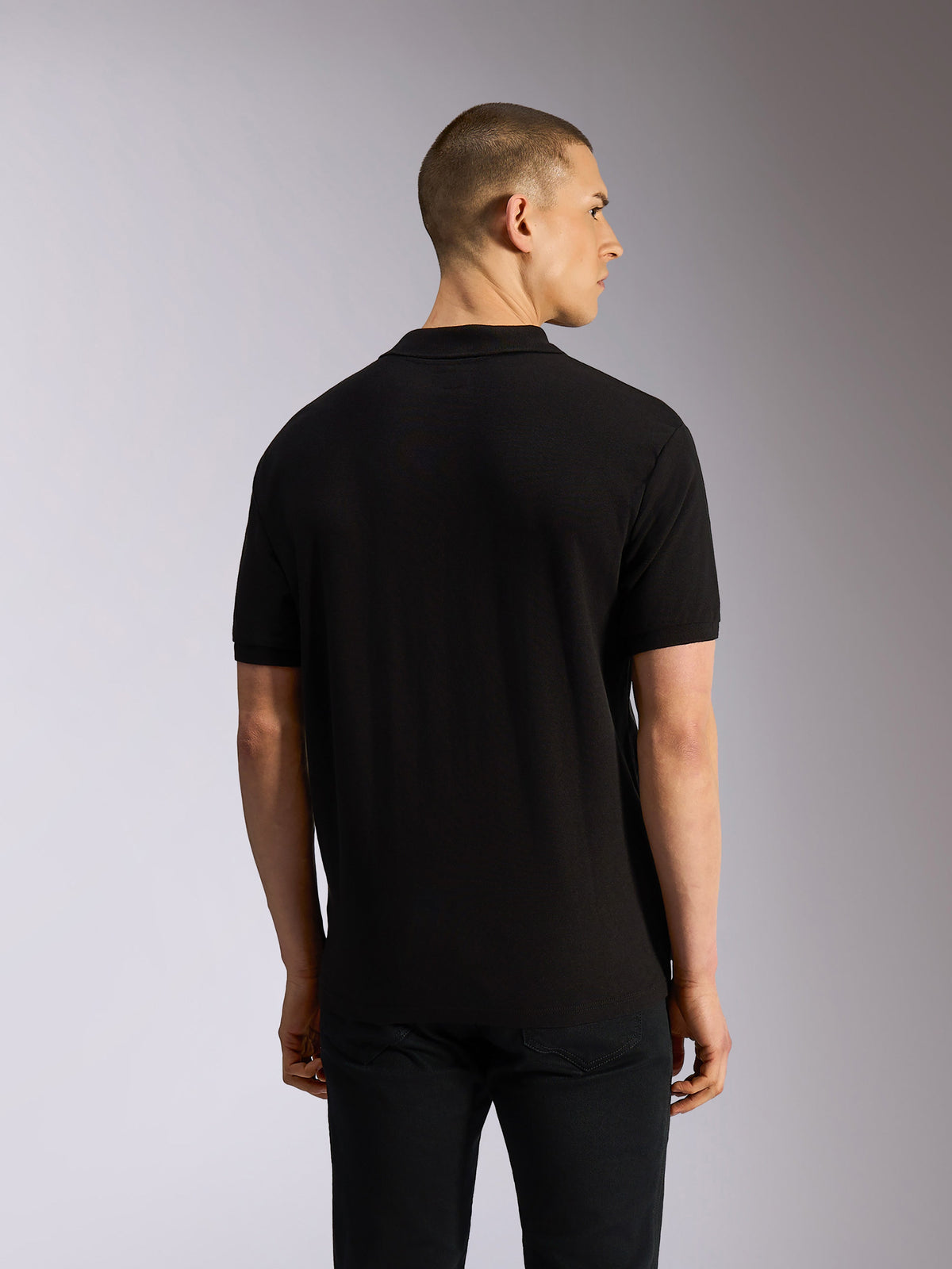 Alpinestars Endeavor Classic Polo, poloshirt met korte mouwen, zwart, achteraanzicht op model, klassiek piqué breisel met geribde kraag en manchetten, casual motorsport-geïnspireerde kleding