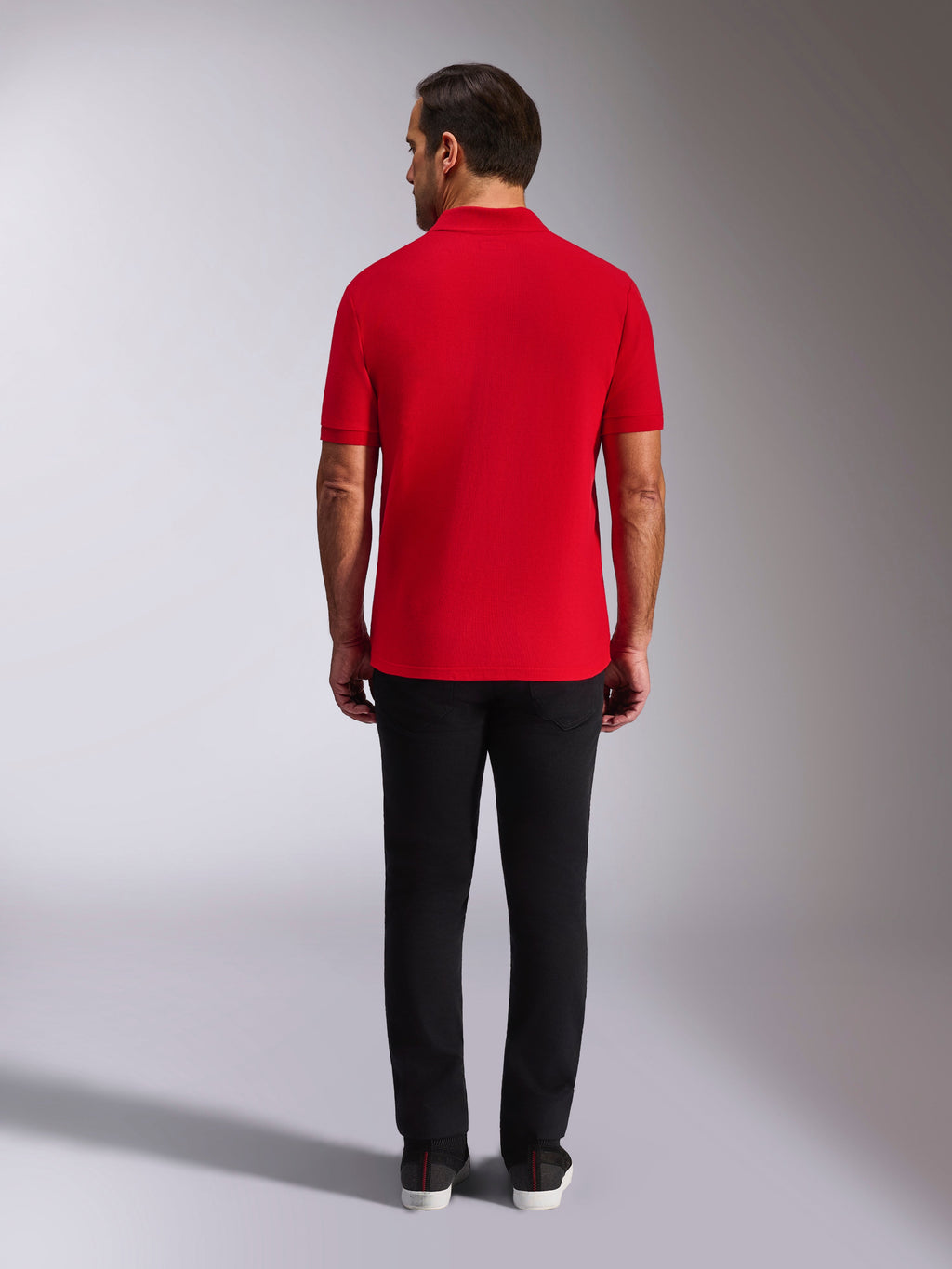 Alpinestars Endeavor Classic Polo, rood piqué poloshirt, achteraanzicht, gedragen met een zwarte broek, casual motorsport streetwear met geribde kraag en manchetten