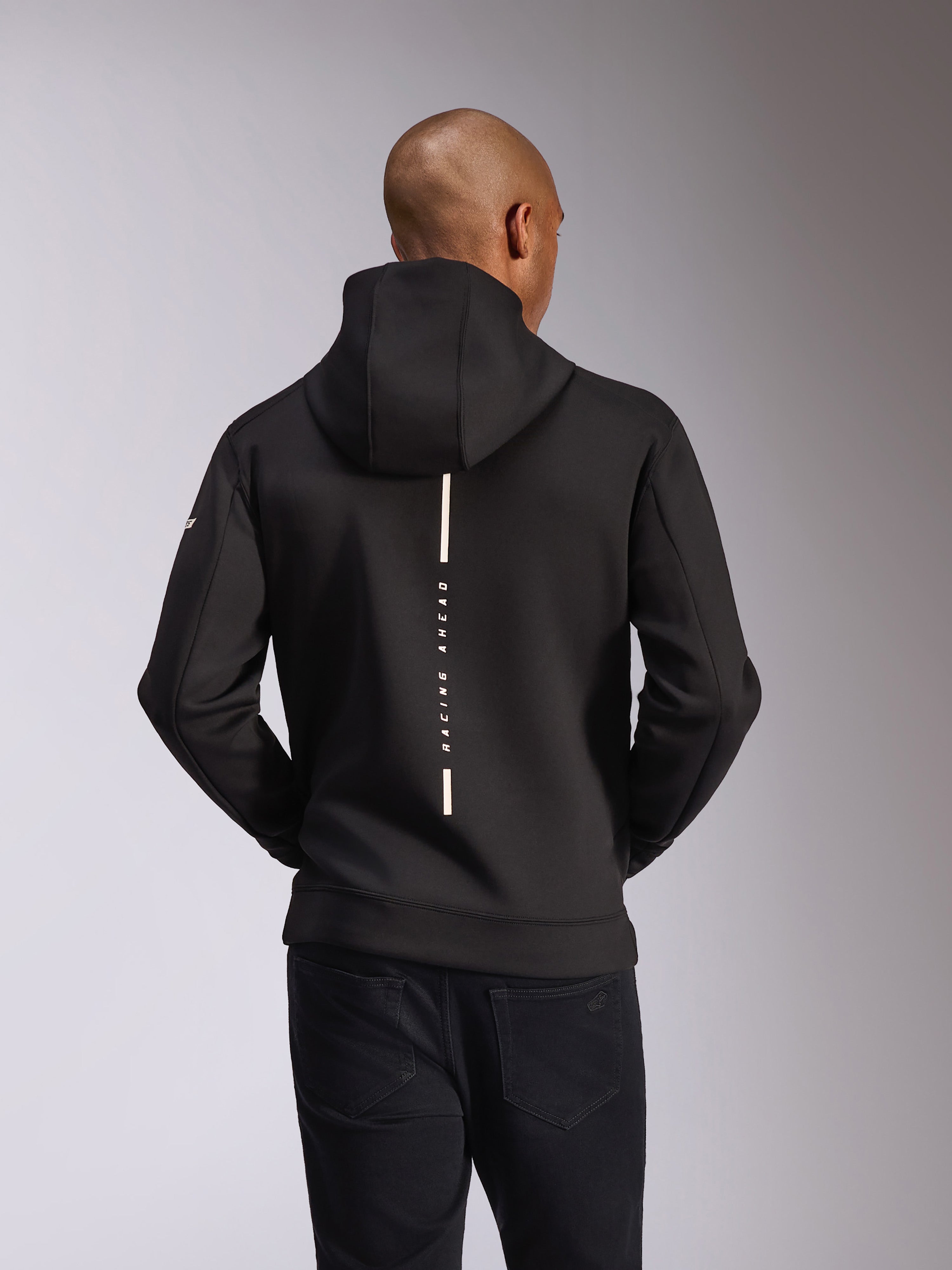 Alpinestars Insight Hoodie, achteraanzicht, zwart, verticale witte streep met de tekst 'RACING AHEAD', woordmerk op de mouw, casual motorsport-geïnspireerde streetwear