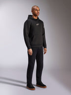 Alpinestars Insight Hoodie, zwart, casual pullover fleece hoodie met wit Astars-logo op de borst, kangoeroezak, gedragen met zwarte broek en sneakers, volledige studio-opname, motorsport-geïnspireerde streetwear