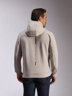 Alpinestars Insight Hoodie in Cement, achteraanzicht van model in een lichtgrijze pullover sweatshirt, voorzien van een zwart verticaal streeplogo met de tekst 'RACING AHEAD', casual op motorsport geïnspireerde hoodie van dubbelzijdige fleece.