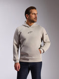 Alpinestars Insight Hoodie, casual sportkleding, Cement grijs, pullover-ontwerp met kangoeroezak en klein zwart Astars-logo op de borst, lange mouwen met Alpinestars-woordlogo op de linkerarm, gedragen door een model met een donkere spijkerbroek, lifestyle motorsportkleding