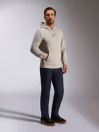 Alpinestars Insight Hoodie, casual streetwear, cementgrijs met zwart Astars-logo op de borst, pullover-ontwerp met kangoeroezak, gedragen met donkerblauwe jeans en zwarte sneakers, moderne op motorsport geïnspireerde stijl