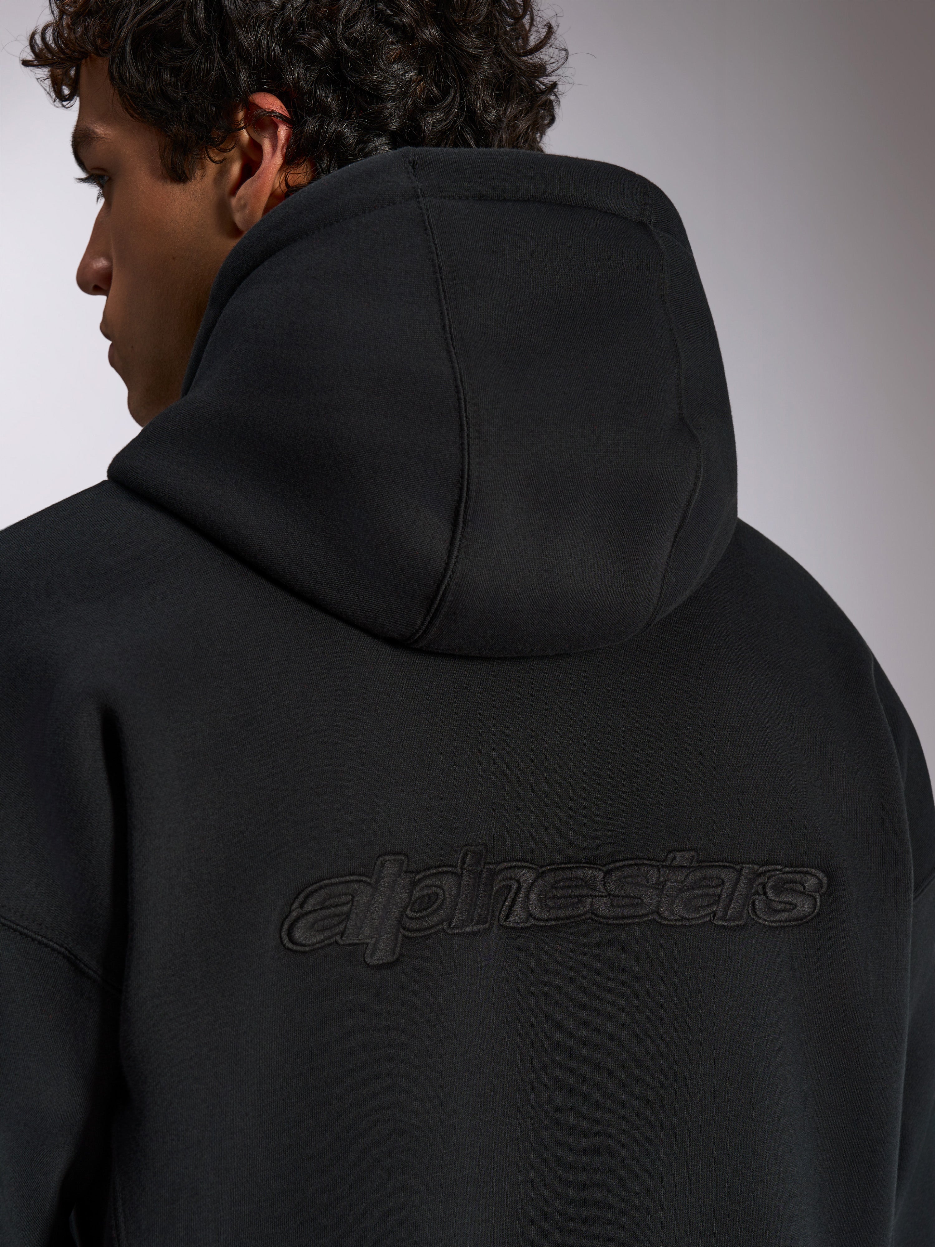 Alpinestars Emergent Oversized Hoodie, zwarte casual streetwear, achteraanzicht met 3D-geborduurd Alpinestars-woordlogo, oversized pasvorm met premium fleecetextuur
