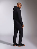 Alpinestars Ellipsoid Hoodie, zwarte casual streetwear, achteraanzicht op mannelijk model, fleece pullover met capuchon, geribde manchetten en zoom, gedragen met zwarte broek en sneakers, modern op de motorsport geïnspireerd ontwerp