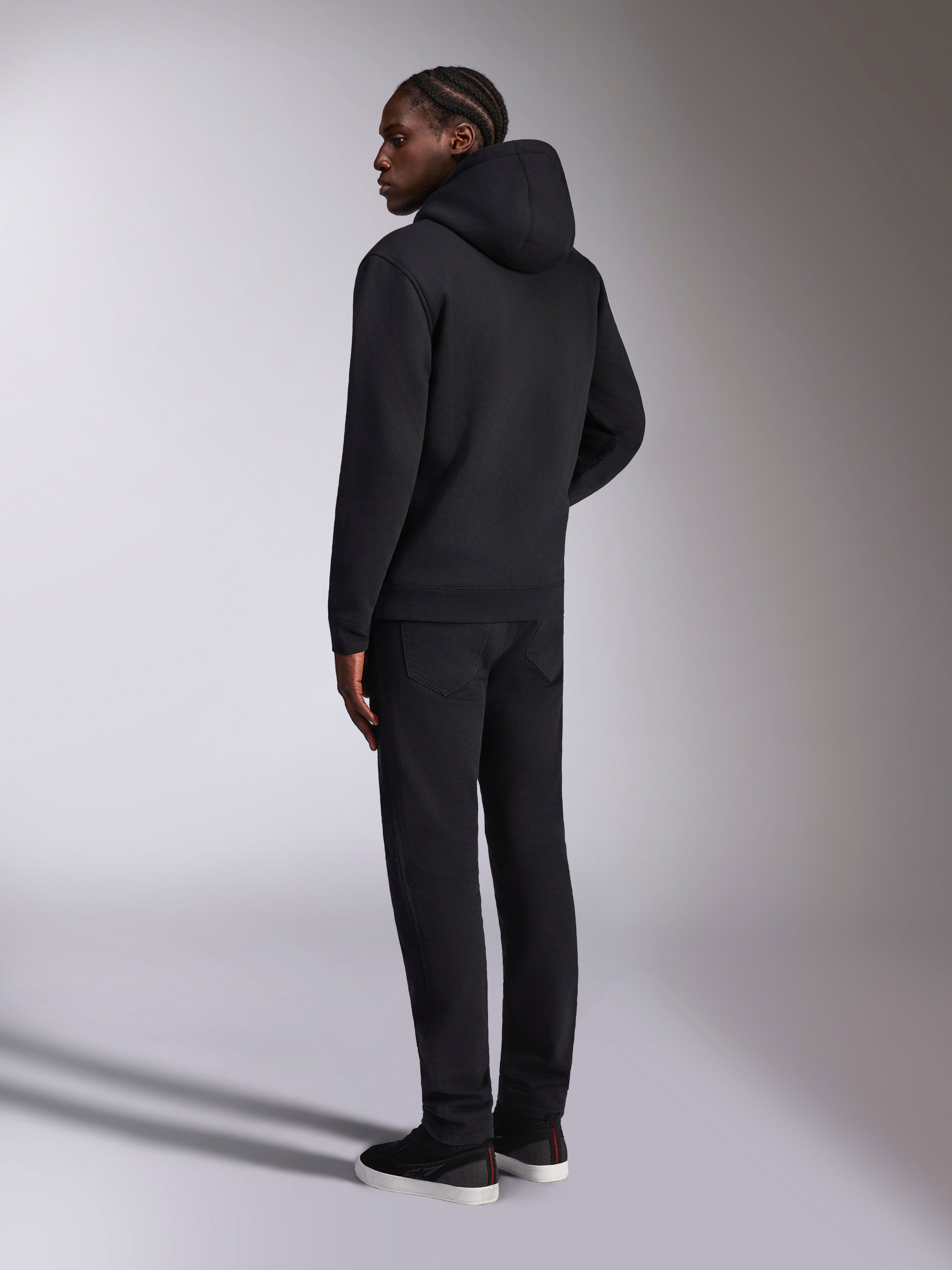 Alpinestars Pulse Hoodie, casual streetwear, zwart, achteraanzicht van model met effen zwarte pullover fleece met capuchon, minimalistisch ontwerp met geribde manchetten en zoom