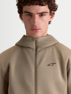Alpinestars Cypher hoodie, beige sportswear fleece hoodie met volledige ritssluiting voor heren en dames, voorzien van een capuchon met hoge hals, technische tri-blend dubbelzijdige stof en een minimalistisch Alpinestars-logo op de borst.