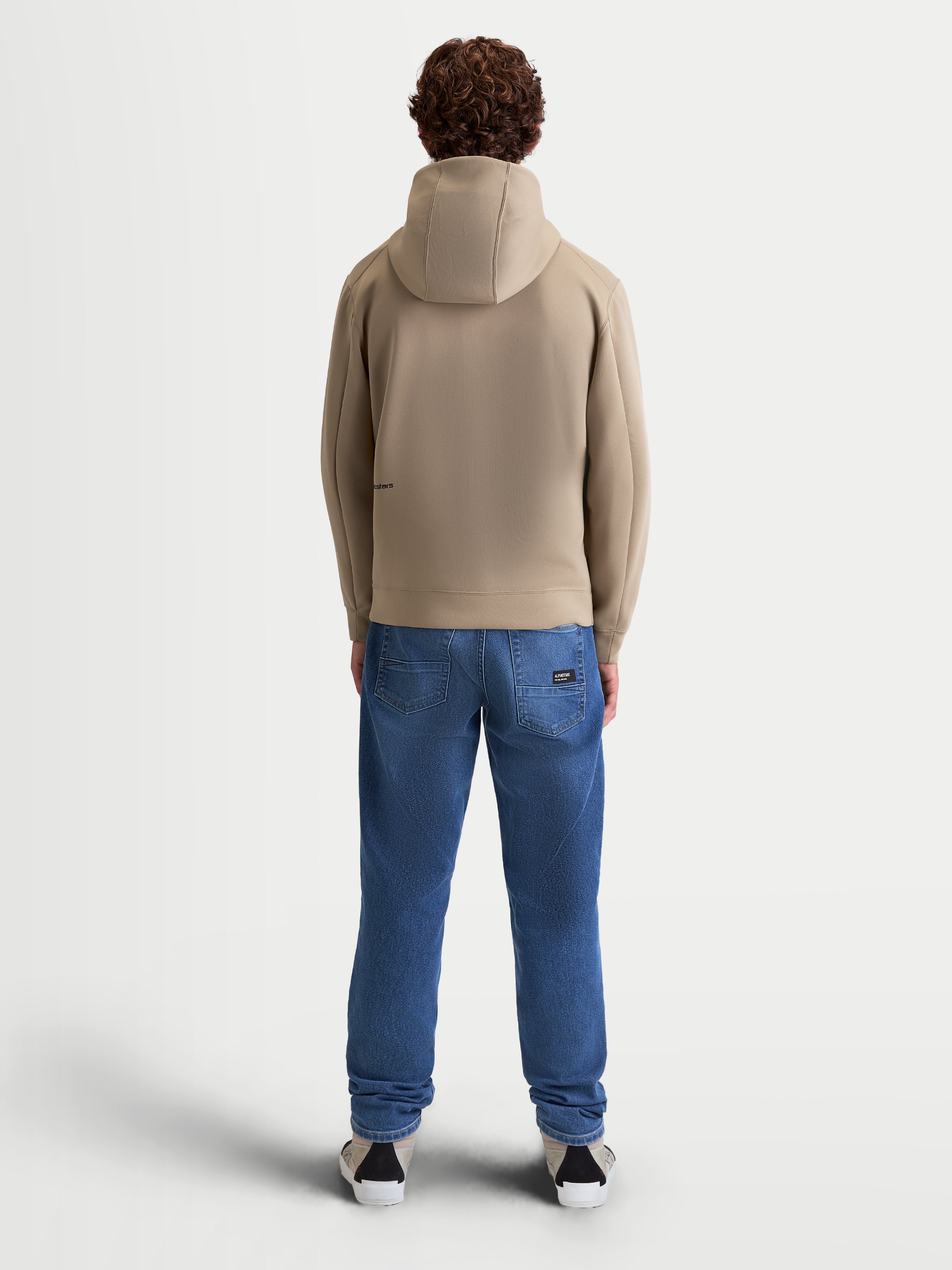 Alpinestars Cypher hoodie, sportswear fleece met ritssluiting voor heren en dames, beige, achteraanzicht op model, capuchon met hoge hals en meshvoering, tri-blend performance stof, motorsport-geïnspireerde casual sportswear