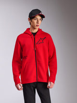 Alpinestars Transverse Hoodie, rode fleece hoodie met rits, zwart Astars-logo op de borst en 'One Goal'-print, casual streetwear-stijl gedragen met een zwarte pet en broek