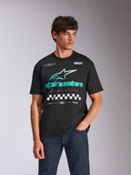 Alpinestars Aplomb Oversized CSF Tee, T-shirt met korte mouwen, zwart, met een groot groenblauw en wit Astars combo-logo met geblokte graphic, gedragen door een mannelijk model met een donkerblauwe jeans, casual motorsport streetwear