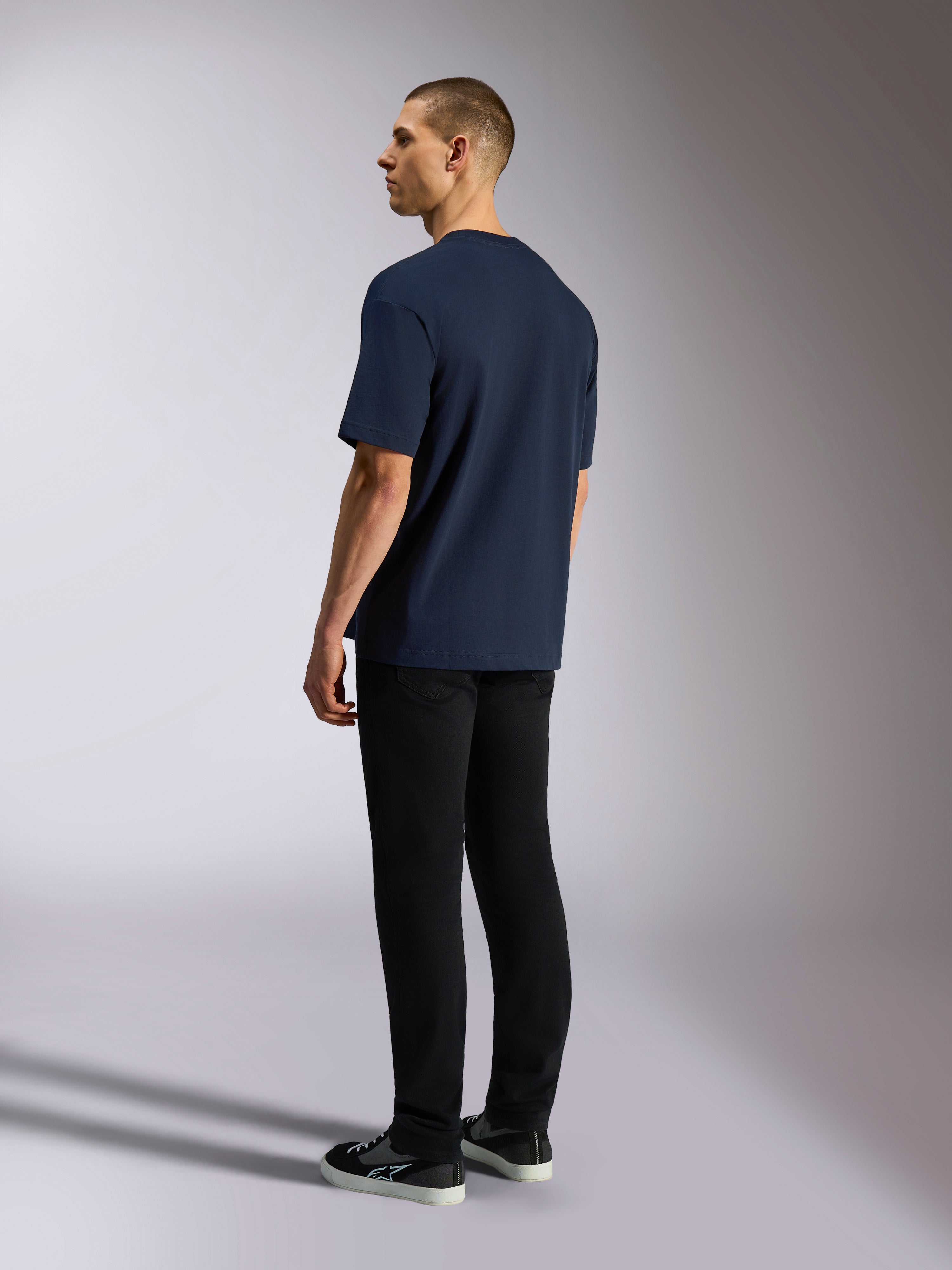 Alpinestars Aplomb Oversized CSF Tee, T-shirt met korte mouwen, navy, achteraanzicht op model, gedragen met zwarte broek en sneakers, casual op de motorsport geïnspireerde streetwear