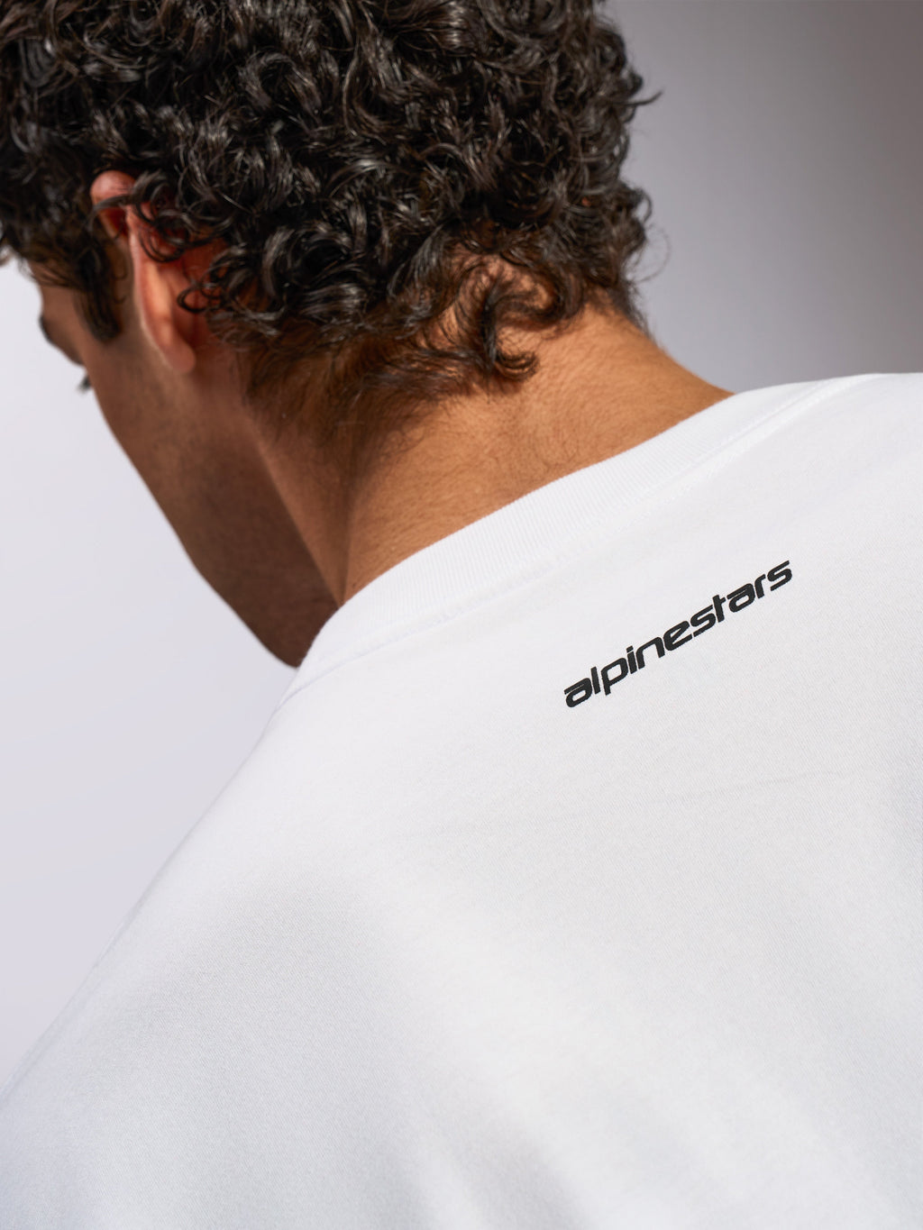 Alpinestars Focused Oversized CSF Tee, T-shirt met korte mouwen, wit, close-up van de achterkant van de nek met klein zwart Alpinestars-woordmerklogo, casual motorsport-geïnspireerd ontwerp