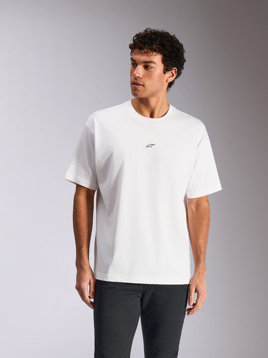 Alpinestars Focused Oversized CSF Tee, wit T-shirt met korte mouwen, klein zwart Astars-logo op de borst, relaxed fit gedragen door model, casual motorsport streetwear