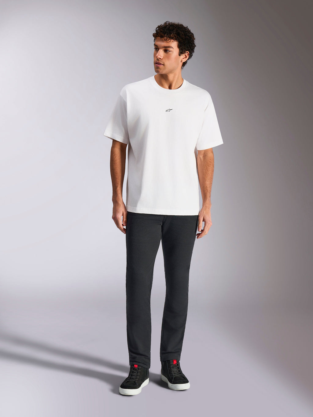 Alpinestars Focused Oversized CSF Tee, T-shirt met korte mouwen, wit, klein zwart Astars-logo op de borst, casual streetwearstijl, gedragen door model met donkere broek en zwarte hoge sneakers