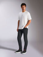 Alpinestars Focused Oversized CSF Tee, T-shirt met korte mouwen, wit, met een klein zwart Astars-logo op de borst, gedragen door een mannelijk model met een donkere broek en zwarte sneakers, casual motorsport-geïnspireerde streetwear