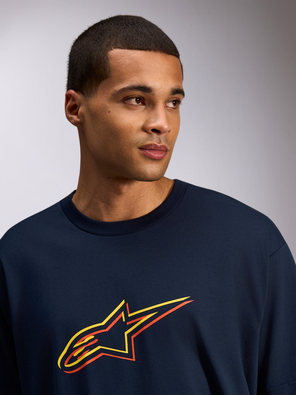 Alpinestars Alter Oversized CSF Tee, T-shirt met korte mouwen, Navy, Astars-logo met geel en oranje kleur-offset print, casual streetwearstijl gedragen door een model