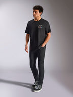 Alpinestars Wild Oversized CSF Tee, T-shirt met korte mouwen, zwart, meerkleurig Astars-logo op de borst, casual streetwear stijl gedragen door een model met zwarte broek en hoge sneakers