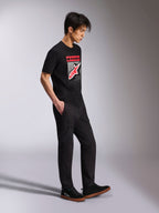 Alpinestars Noka CSF Tee, T-shirt met korte mouwen, zwart, Astars-logo aan de voorzijde met rood en wit MX-verloop, gedragen met een zwarte cargobroek en sneakers, casual motorsport-geïnspireerde streetwear
