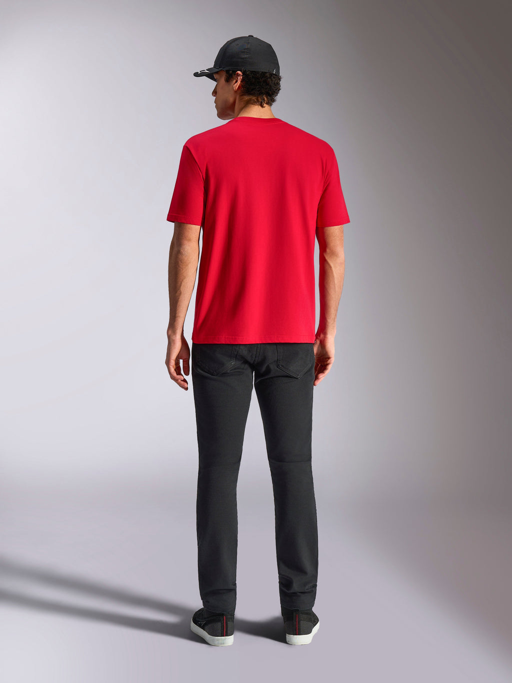 Alpinestars Noka CSF Tee, T-shirt met korte mouwen, rood, achteraanzicht, gestyled met een zwarte broek en een zwarte baseballpet, casual streetwear geïnspireerd op de motorsport